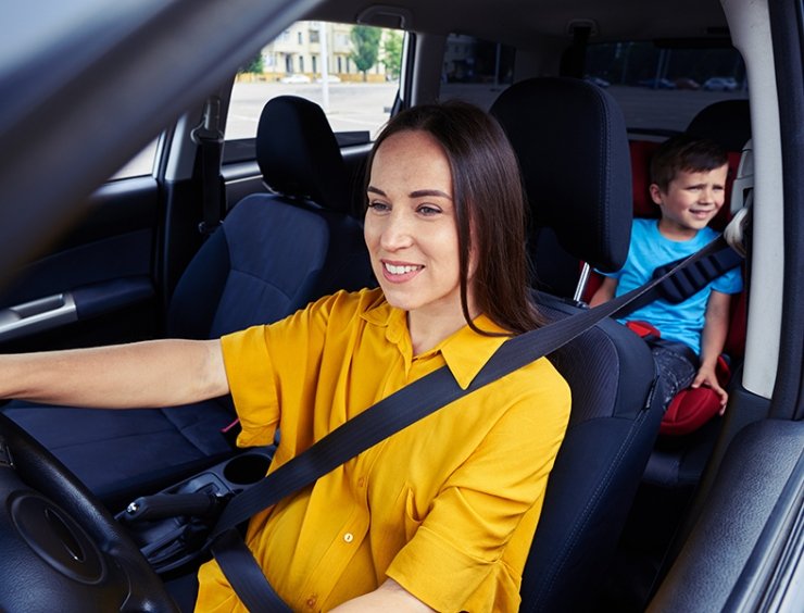 mamma in automobile con figlio seduto nel seggiolino